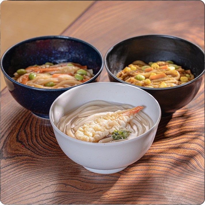 A person eating udon at a table