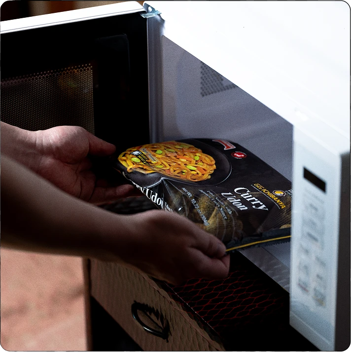 A TableMark udon package being placed in a microwave